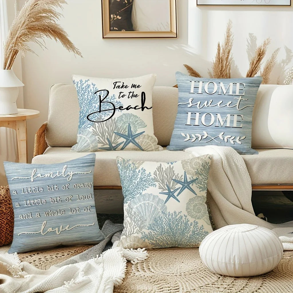 A collection of blue and white decorative pillows featuring starfish and sea motifs on a light sofa.