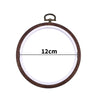Round wooden embroidery hoop with a light-colored fabric inside