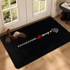 A black anti-slip door mat featuring the Dodge SRT logo and shoe silhouettes on a wooden floor.