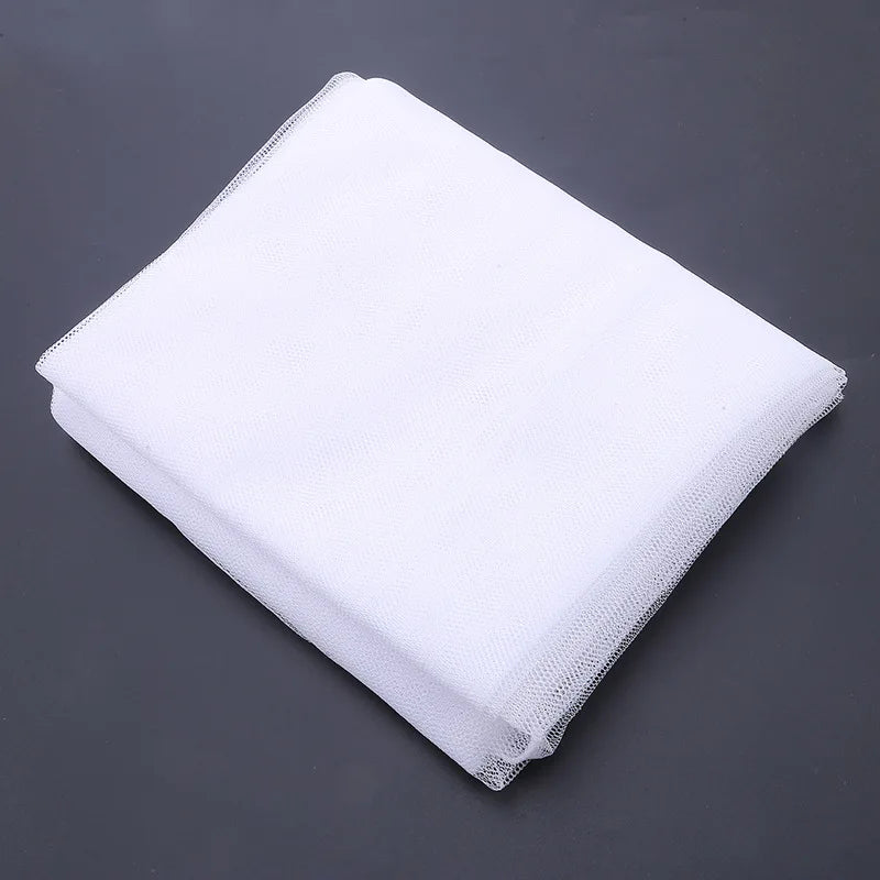 White portable mosquito net fabric folded and displayed on a dark gray surface.