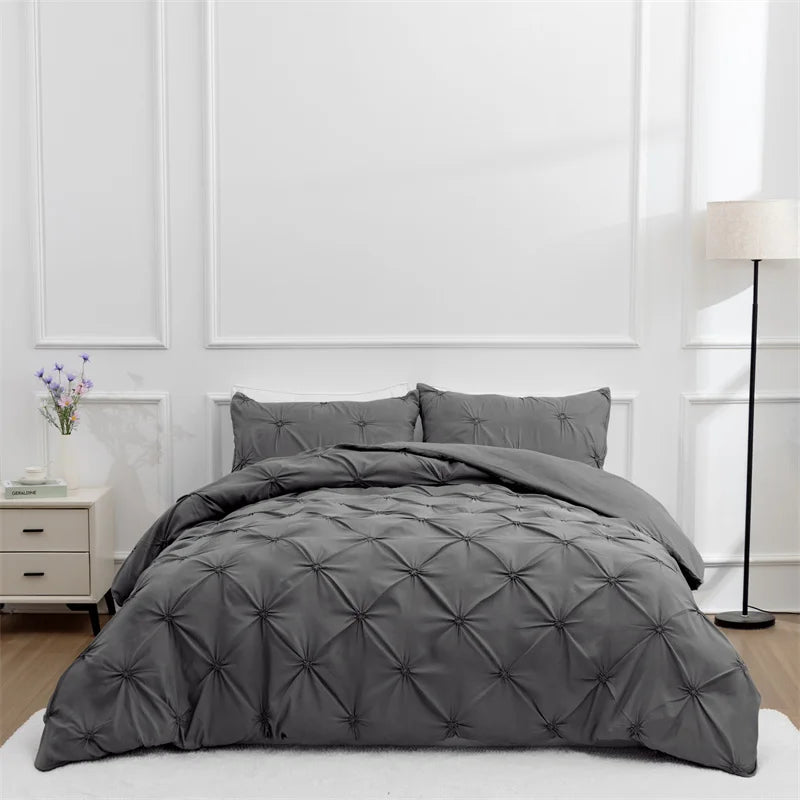 Gray bedding set featuring a quilted duvet on a bed with white paneling.