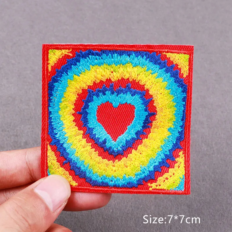 Red embroidered patch featuring a colorful heart design with concentric rings of blue, yellow, and green thread