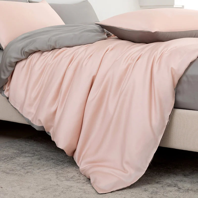 A luxury bamboo duvet cover set featuring soft pink and gray bedding on a bed.