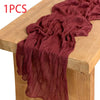 A deep maroon semi-sheer gauze fabric draped over a wooden table surface.
