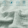 Close-up of a light gray muslin throw blanket showing features like breathability, softness, reversibility, and machine washa