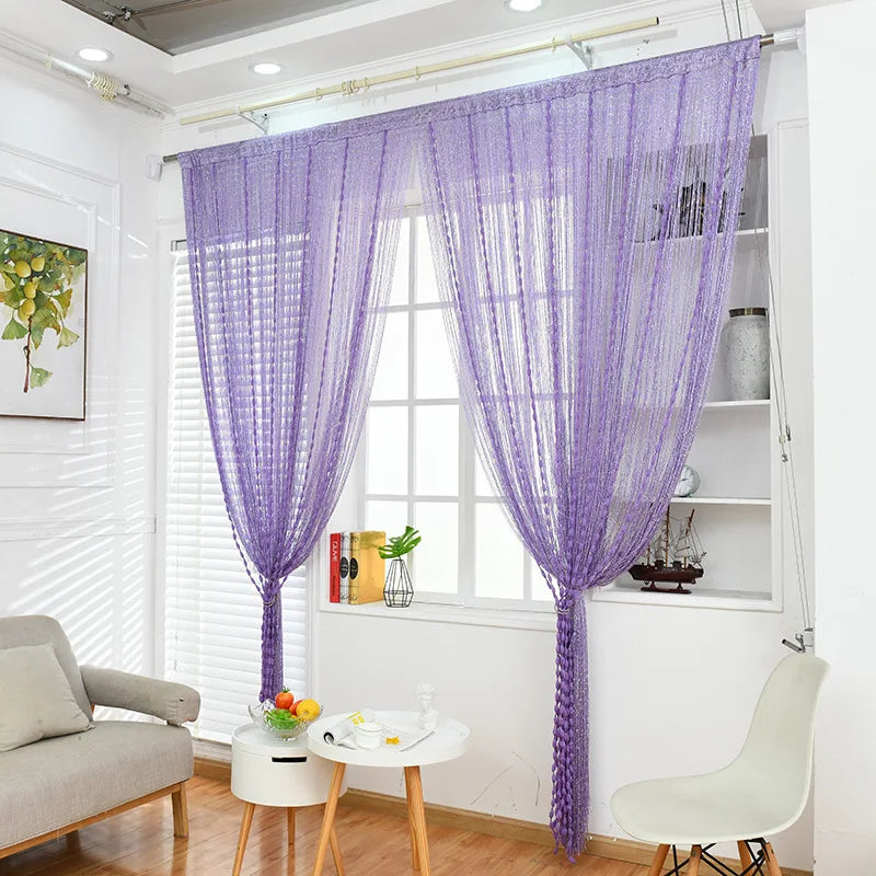 Purple glitter fringe door curtain hanging in a bright room window