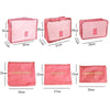 A set of six pink fabric laundry pouches or packing cubes of various sizes displayed side by side.