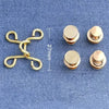 A set of gold-toned metal button snaps for clothing and DIY projects displayed on a blue fabric background.