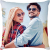 A smiling couple posing for a photo on a light blue background.