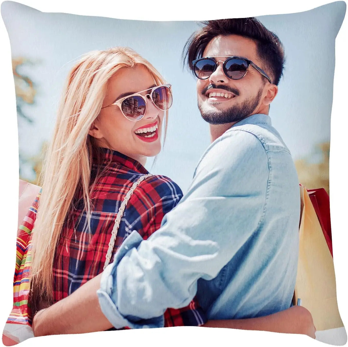 A smiling couple posing for a photo on a light blue background.