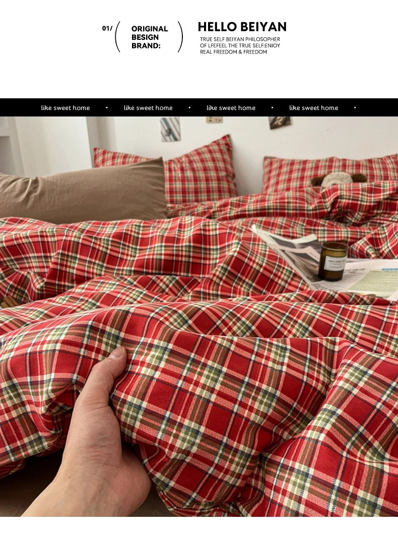 A close-up of a red and green plaid duvet cover set being held by a hand.