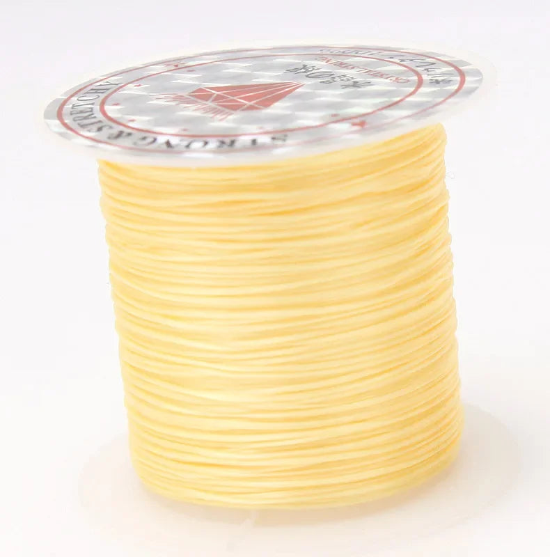 A spool of multicolor elastic beading cord with a transparent label on top.