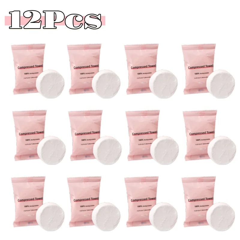 A pack of 12 pink compressed fiber face towels in individual packets.