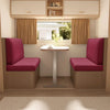 A modern interior featuring two upholstered chairs with pink cushions and a glass table near a window.