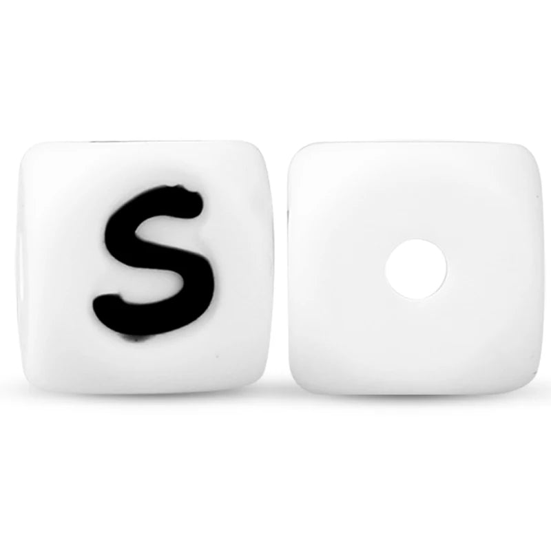 A white silicone alphabet bead shaped like the letter S is shown next to a blank bead.