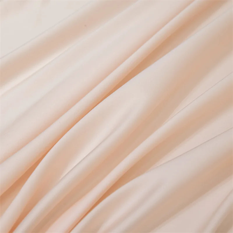 Soft peach colored luxury bamboo flat sheets draped in flowing fabric.