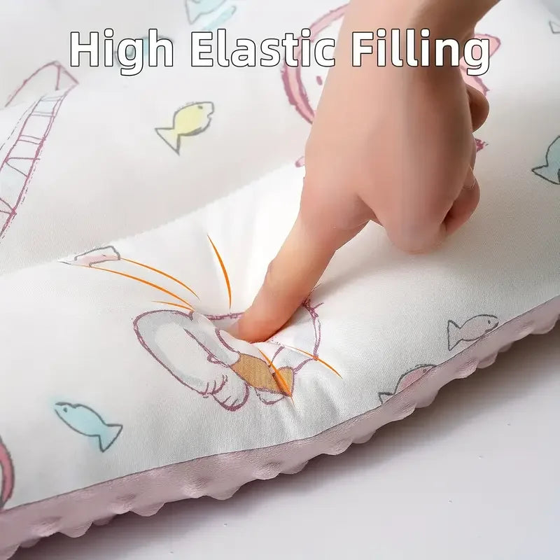 A hand is pressing into a white fiber pillow featuring cartoon fish and other animals.