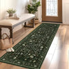 A dark green vintage botanical runner rug laid on a light wood floor in a bright room.