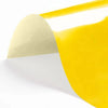 A sheet of yellow heat transfer vinyl being peeled off a white backing.
