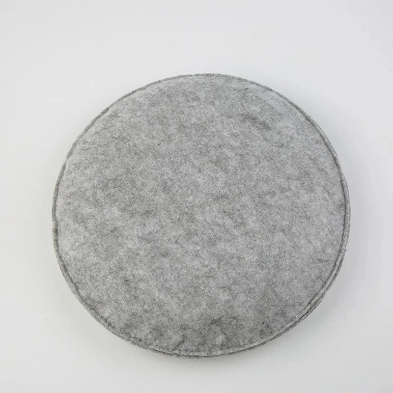 A round, gray needle felting mat pad with a soft, textured surface.