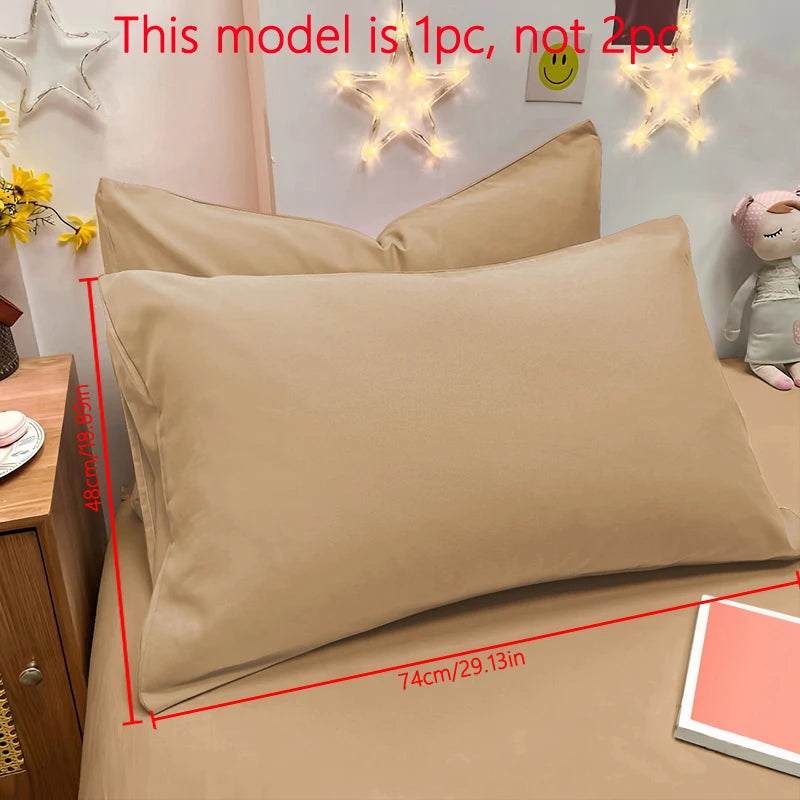 A beige matte solid color pillowcase is shown on a bed with decorative star light fixtures.