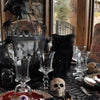 Black spider web lace table runner displayed on a dark tablecloth with skull accents.