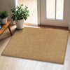 A rectangular natural sisal jute rug placed on a light wood floor near a window with potted greenery.