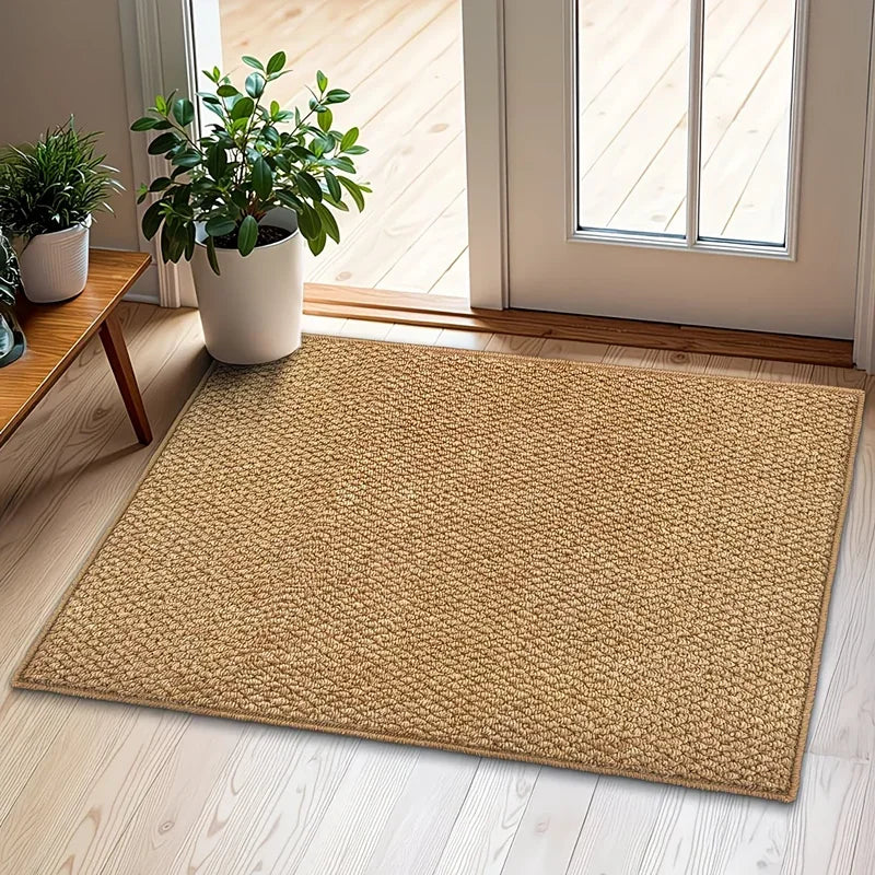 A rectangular natural sisal jute rug placed on a light wood floor near a window with potted greenery.