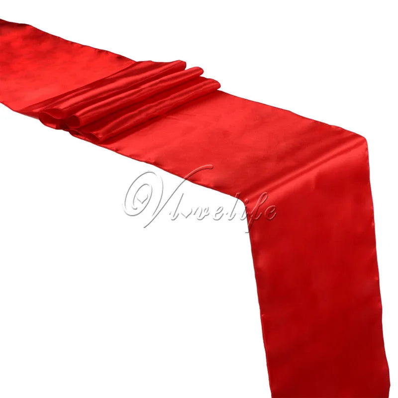 A vibrant red satin table runner draped elegantly for weddings and events.