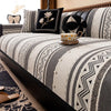 A close-up of a bohemian chenille sofa cushion cover featuring gray and cream geometric patterns with black accents.