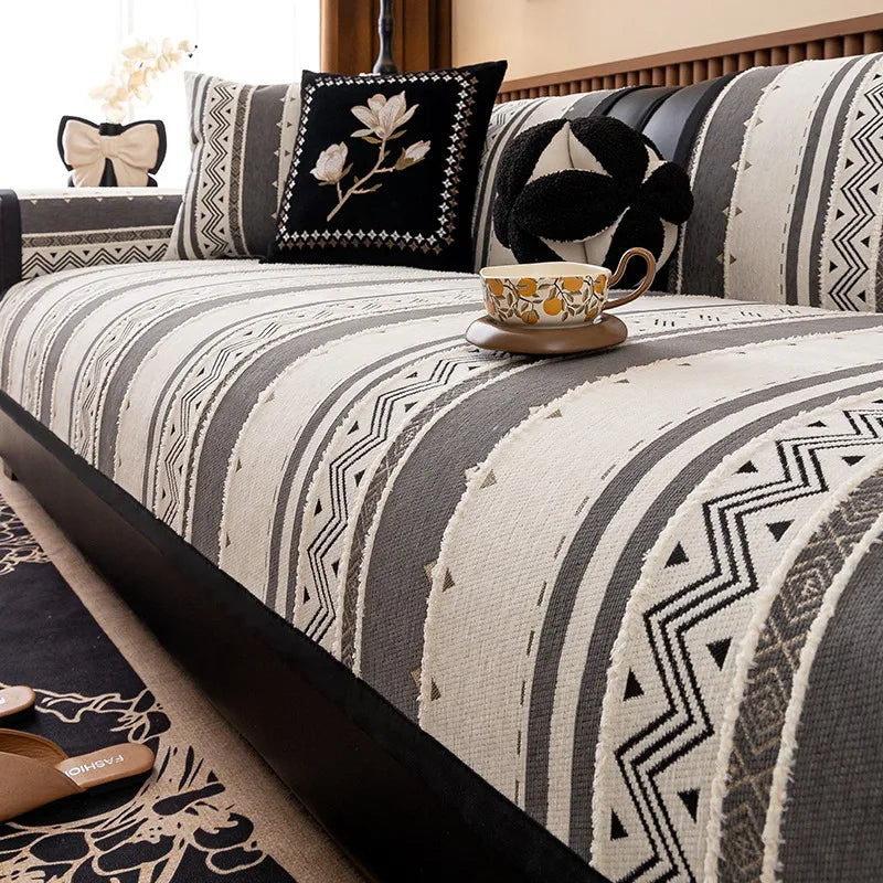 A close-up of a bohemian chenille sofa cushion cover featuring gray and cream geometric patterns with black accents.