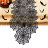 Black lace spider web table runner for Halloween featuring bats and a carved pumpkin