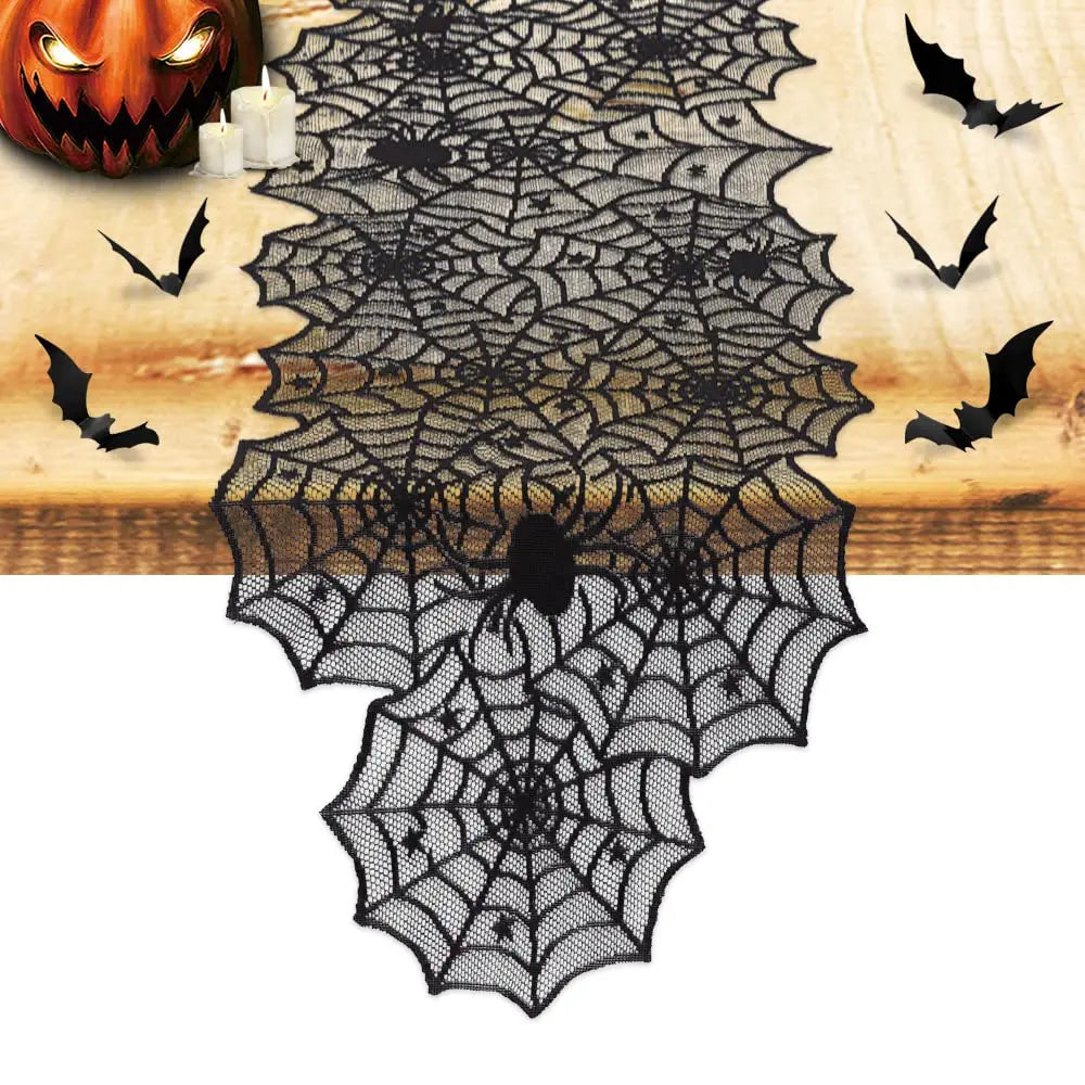 Black lace spider web table runner for Halloween featuring bats and a carved pumpkin