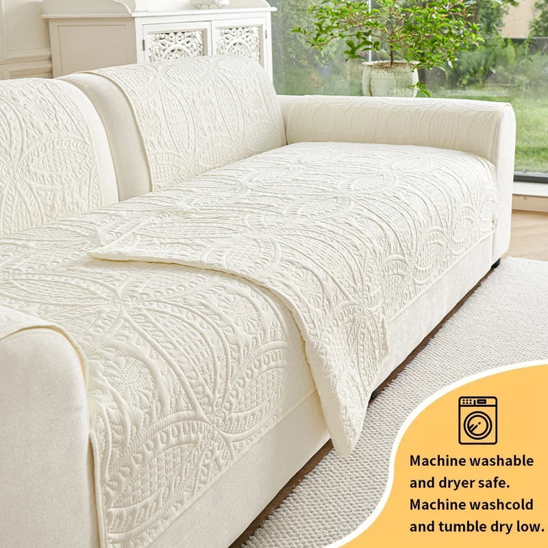 A cream colored sofa cushion with a textured pattern shown on a light-colored sofa.