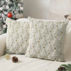 Two light cream knitted cushion covers with a repeating star pattern resting on a white sofa.