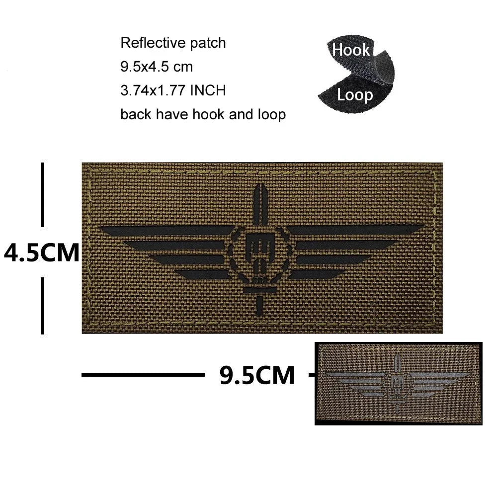 A rectangular olive green embroidered patch featuring a black eagle shield design with a hook and loop backing.