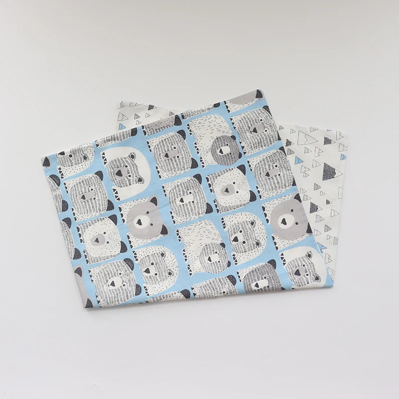 A stack of soft cotton baby pillow covers featuring a pattern of gray and white panda faces on a light blue background.