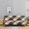 A modern sofa with geometric print spandex slipcovers in shades of gray, beige, and black.
