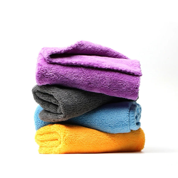 A stack of brightly colored coral fleece microfiber cleaning cloths in purple, gray, and blue.