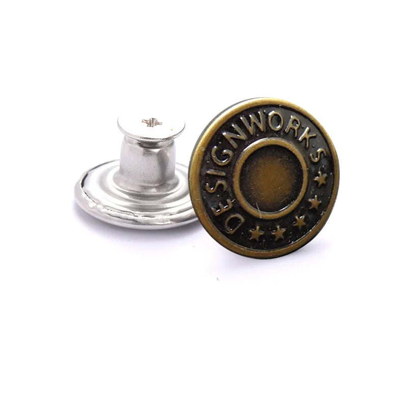 A round brass button with the text DESIGNWORKS stamped around a central circle and surrounded by small stars.