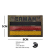 A rectangular dark patch with the word GERMANY embroidered on it, featuring three horizontal reflective patches.