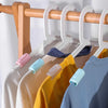 A set of non-slip bed sheet grippers with adjustable clips hanging on a wooden clothes rack.
