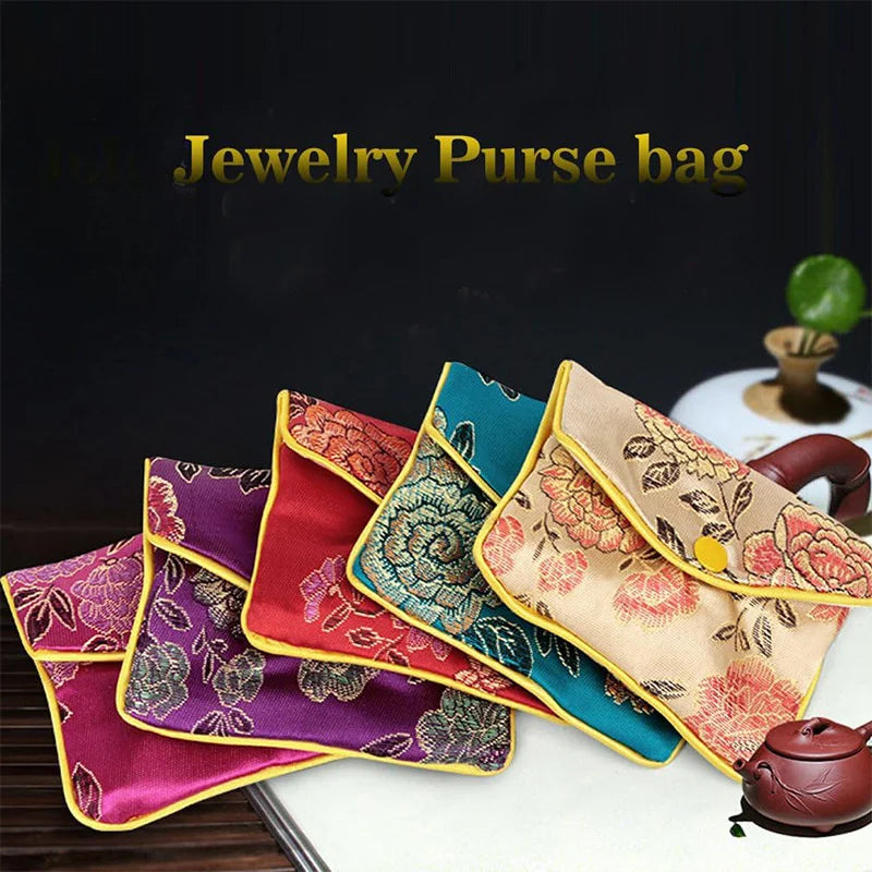 A collection of multi-color silk brocade jewelry purse bags displayed on a white surface.
