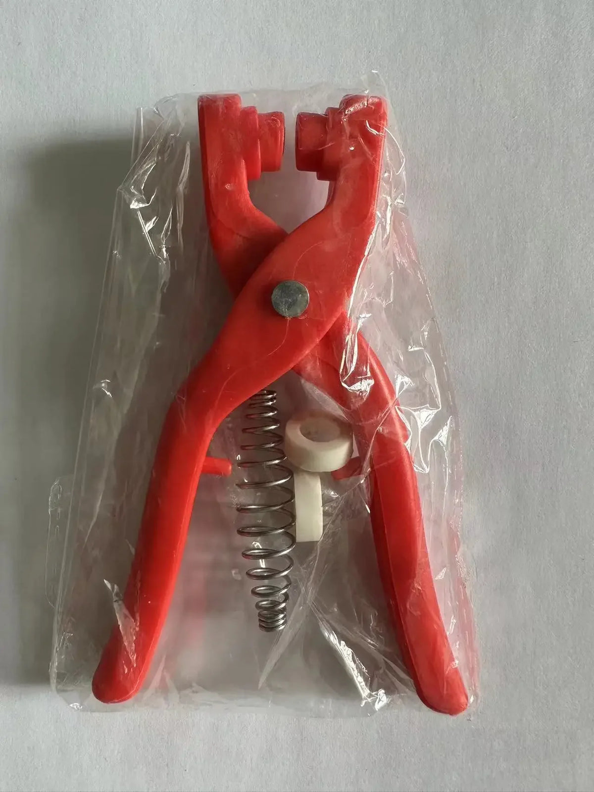 A pair of red five claw buckle clamps packaged in clear plastic, with a spring visible.