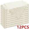 A stack of 12 decorative cloth napkins in a beige or cream color.