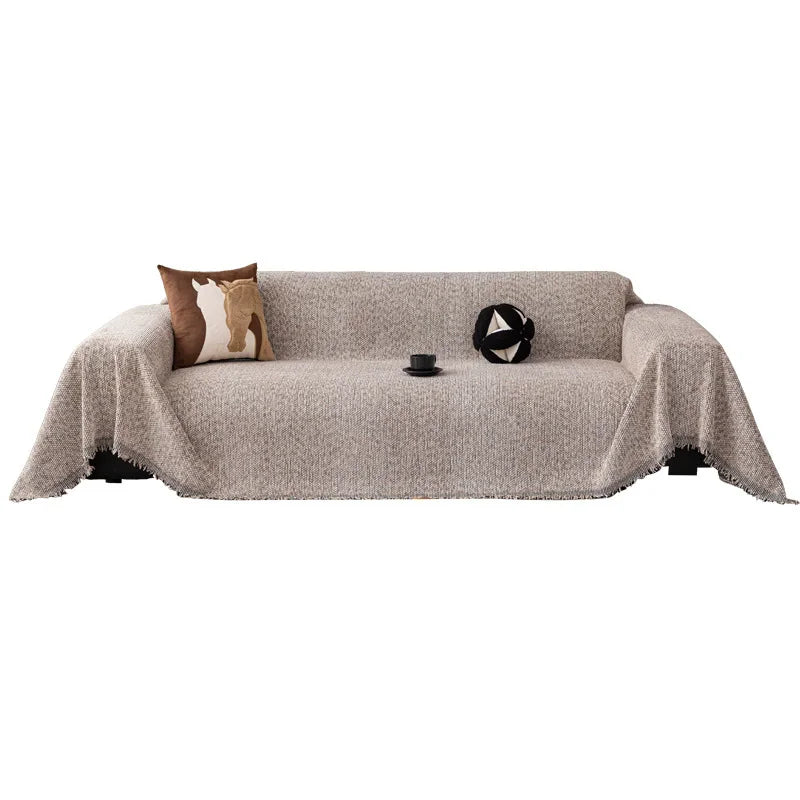 A beige chenille sofa cover with a brown cushion and a black decorative item on a white background.