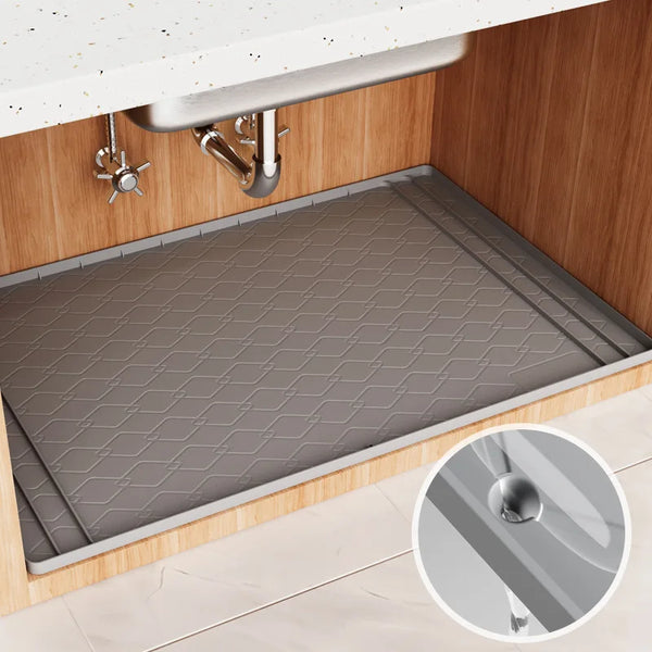 Silicone under sink cabinet liner installed in a wooden cabinet with a stainless steel faucet.