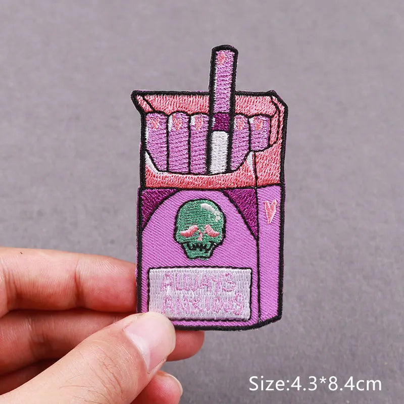 An embroidered horror movie patch featuring a skull and crossbones design on a purple background.