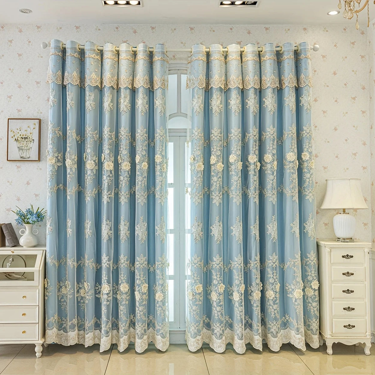 Light blue floral curtains with gold trim hanging in a room.