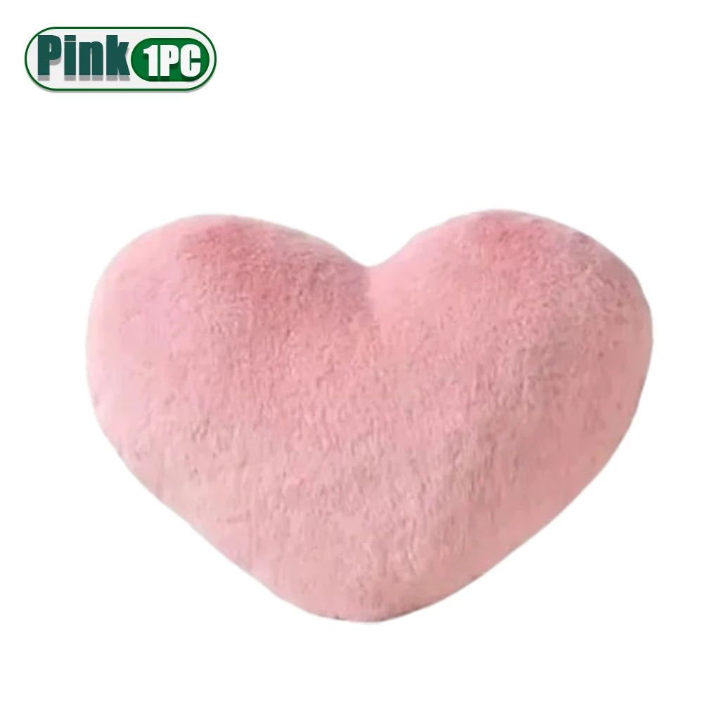 A soft pink heart-shaped plush cushion.